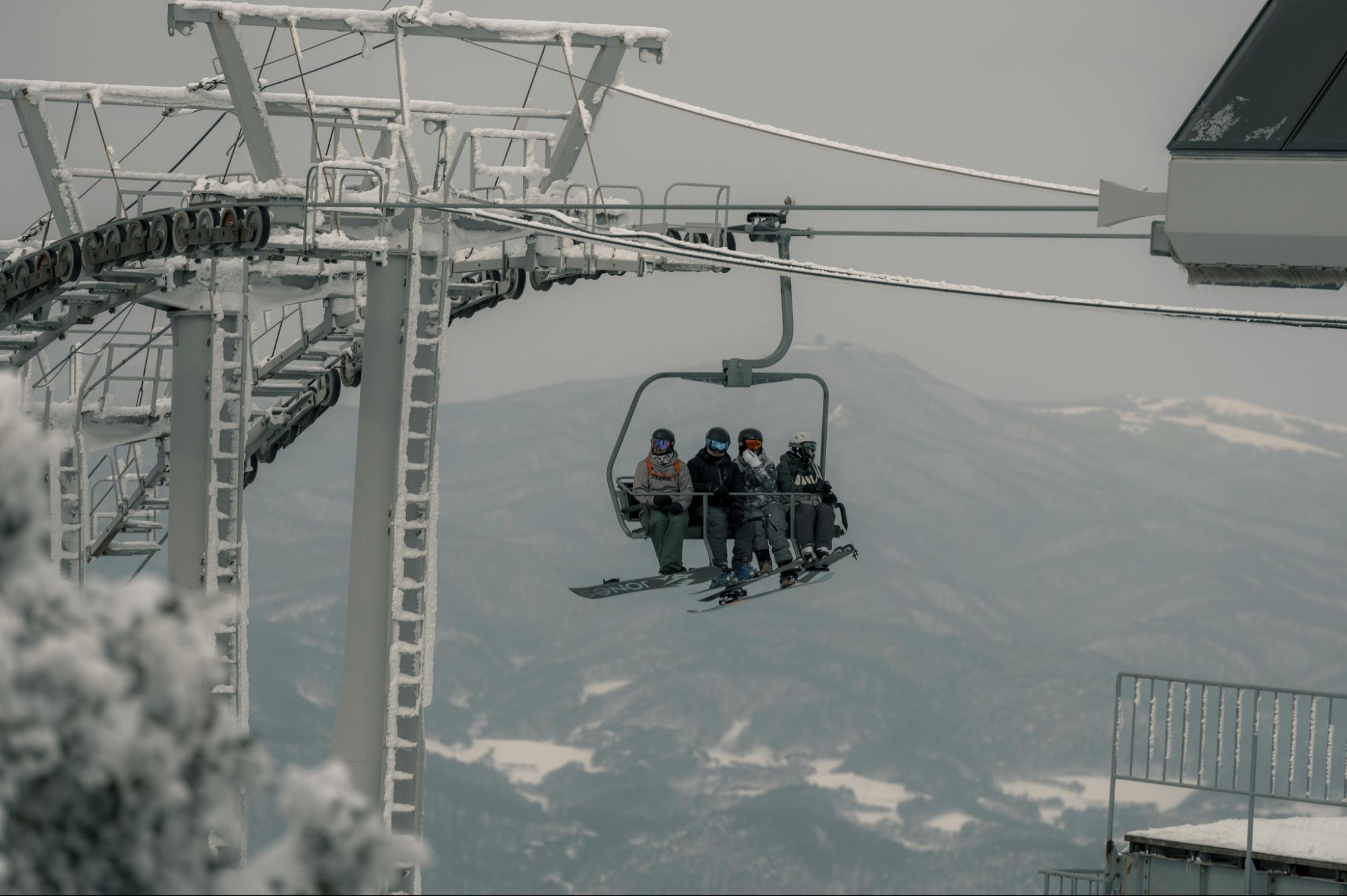Four People Sitting on Ski Lift