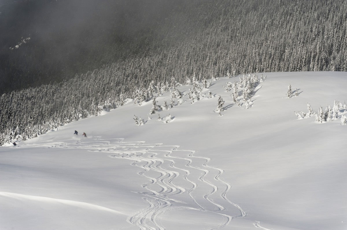 Skiers At The Base Of A Mountain; Whistler - Powderaddicts